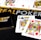 Poker-themed setup featuring a deck of cards on a table with the words 'REAL POKER' visible. Two cards, the King of Clubs and Jack of Diamonds, are prominently displayed. The design is vibrant, with detailed illustrations on the cards.