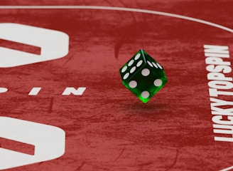 Two green dice with rounded edges are positioned on a red surface that seems to be part of a game board. The surface has white text and numbers on it, including the word 'LUCKYTOPSPIN' in capital letters.